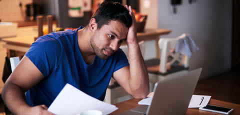 hombre revisando en su computadora portátil su registro de deudas