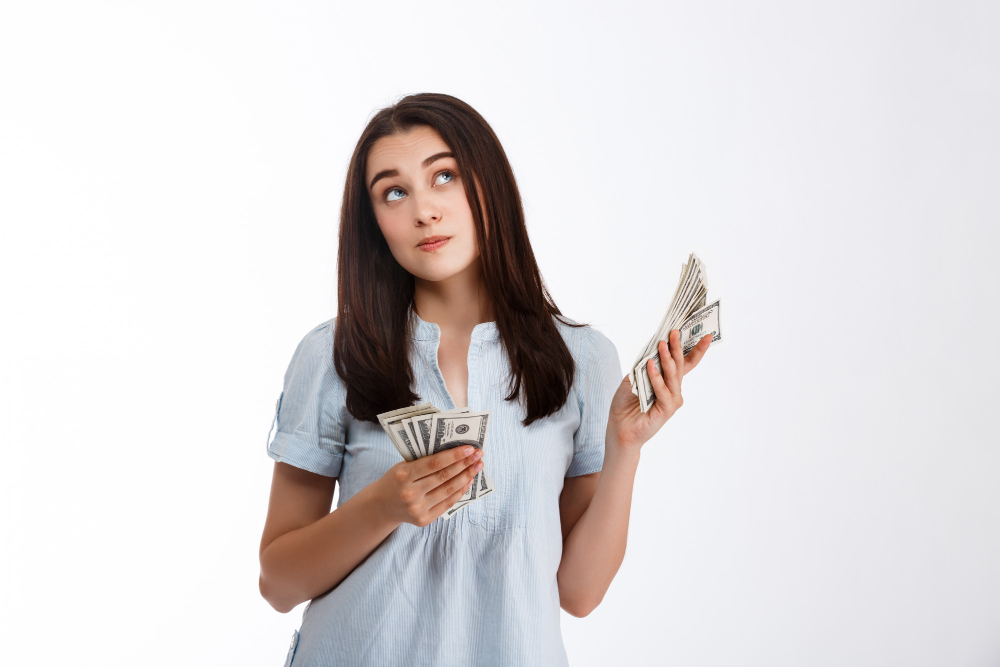 mujer con billetes en su manos pensando en ahorrar