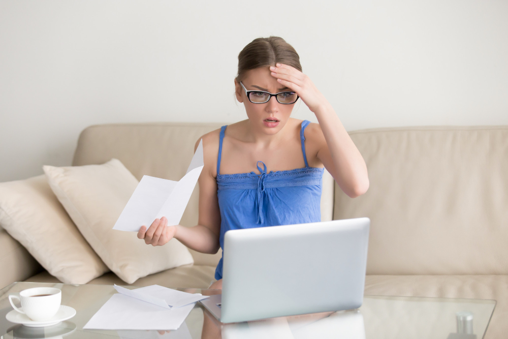 Mujer joven observando finanzas, preocupada